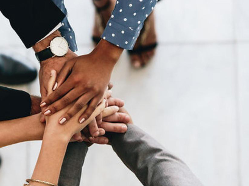 Diverse team of professionals joining hands together in unity