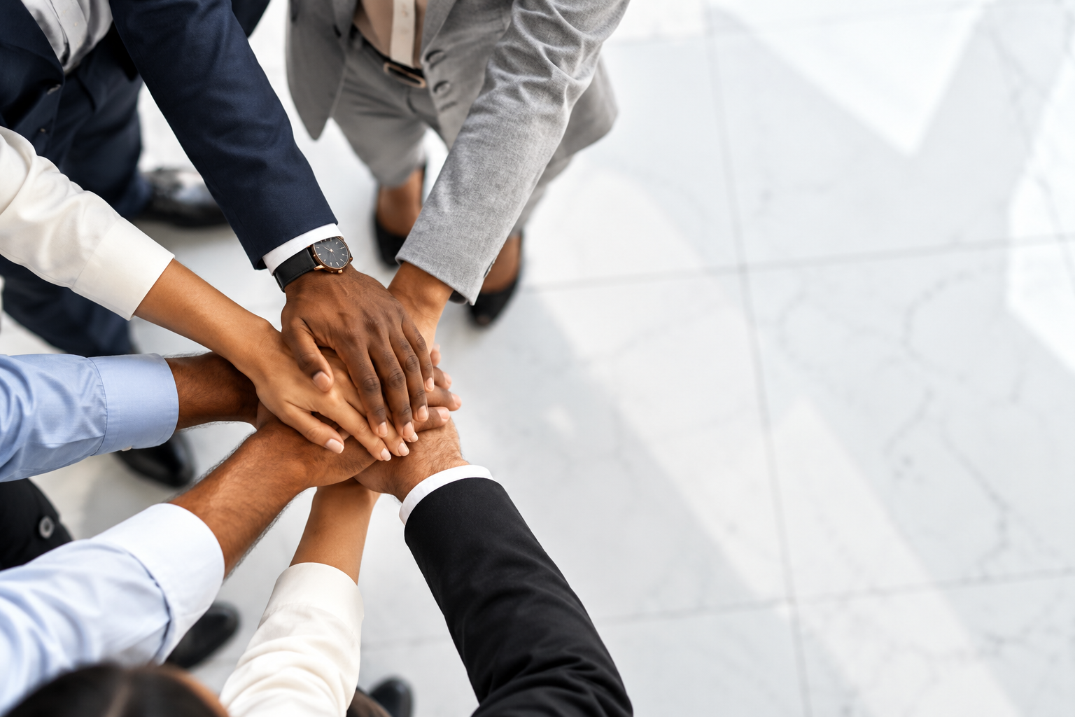 Diverse team of professionals joining hands together in unity